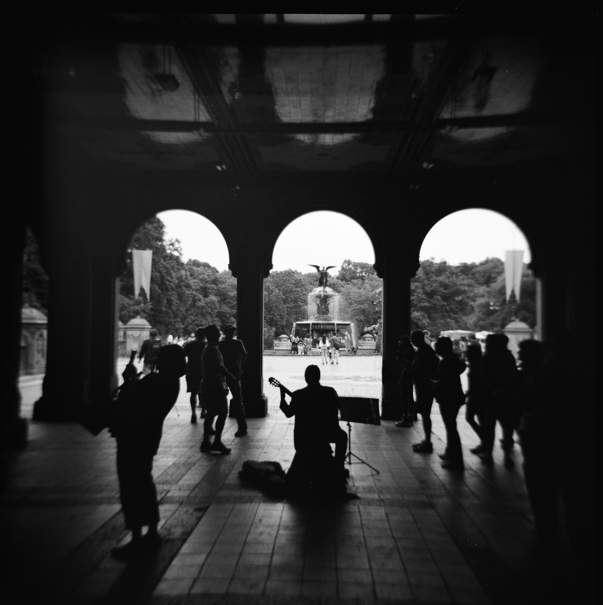 Silhouetted guitarist beneath the arches of Bethesda Terrace, Central Park, NYC.