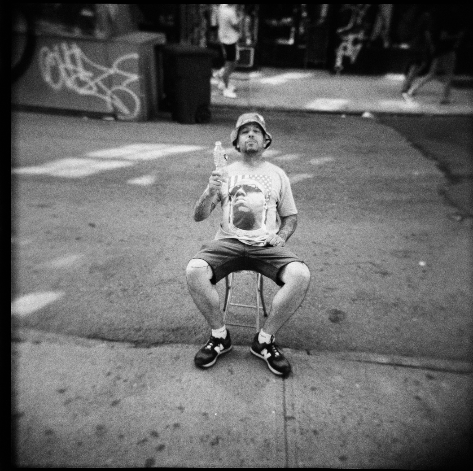 Young man on a folding stool eating an ice-cream cone, sidewalk in SoHo, New York.